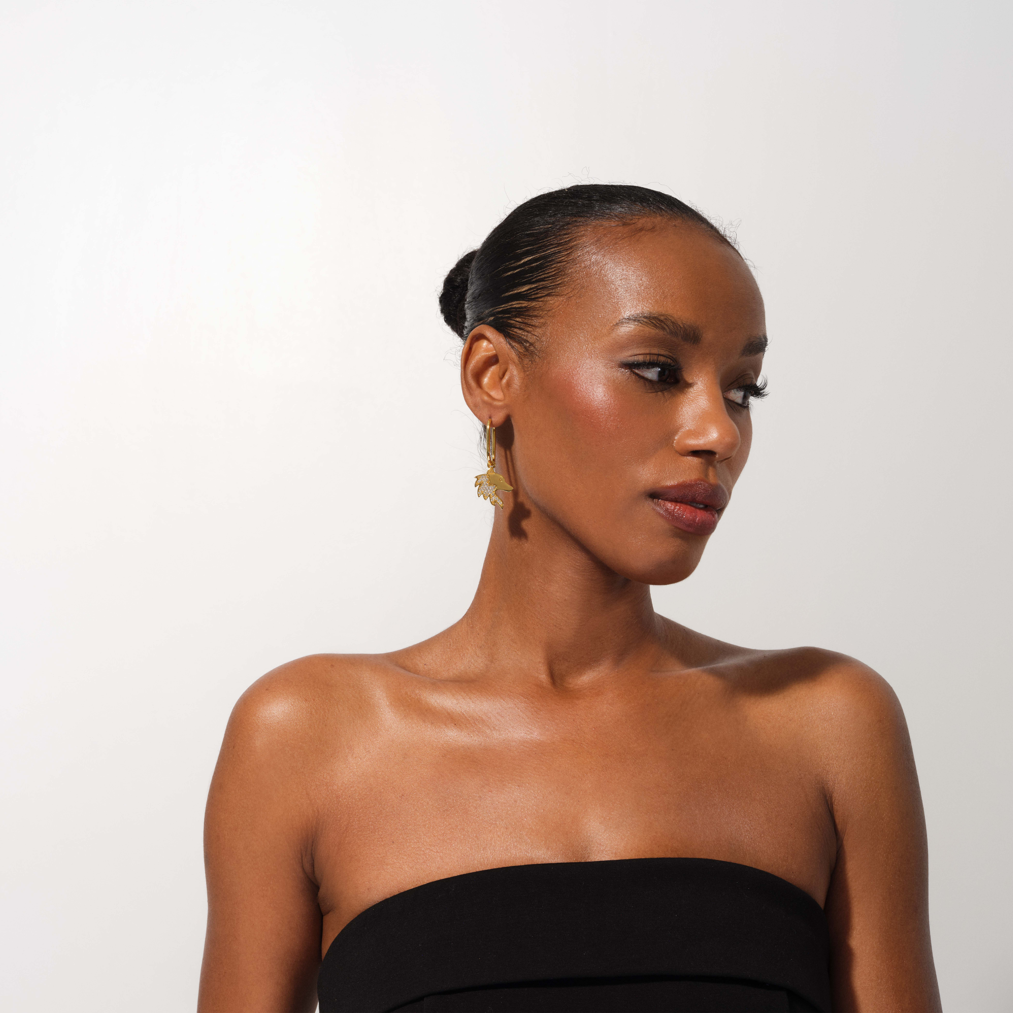 Woman wearing a black strapless dress against a white background