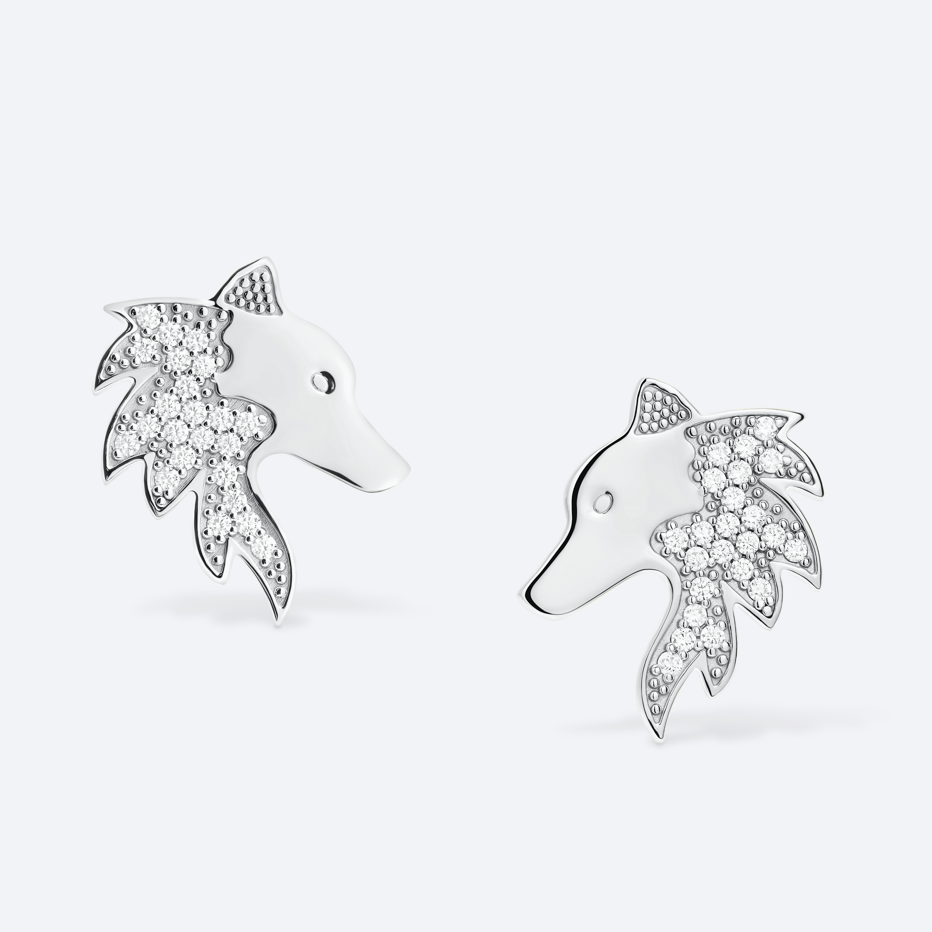 Silver earrings shaped like dolphins with diamond accents on a white background