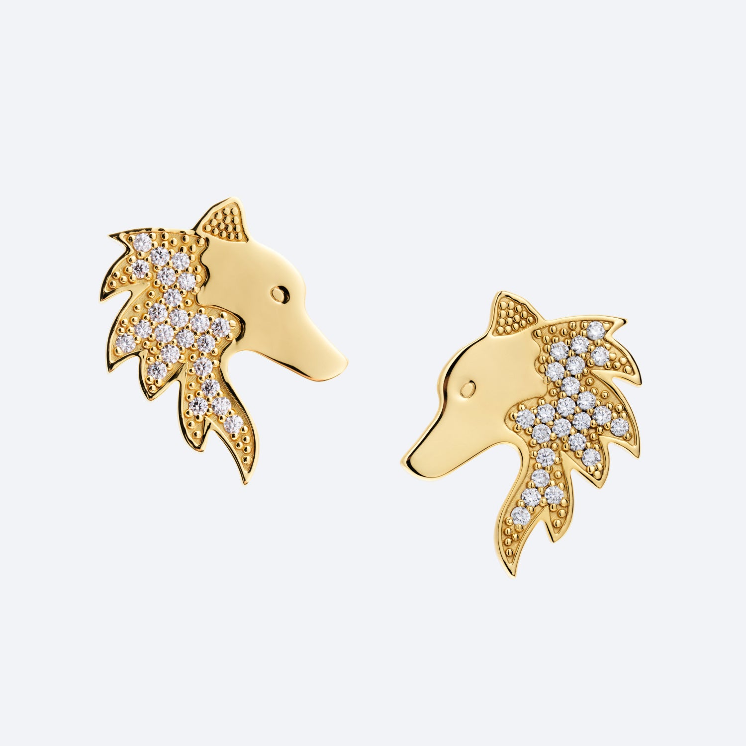 Gold dog-shaped earrings with diamond accents on a light gray background