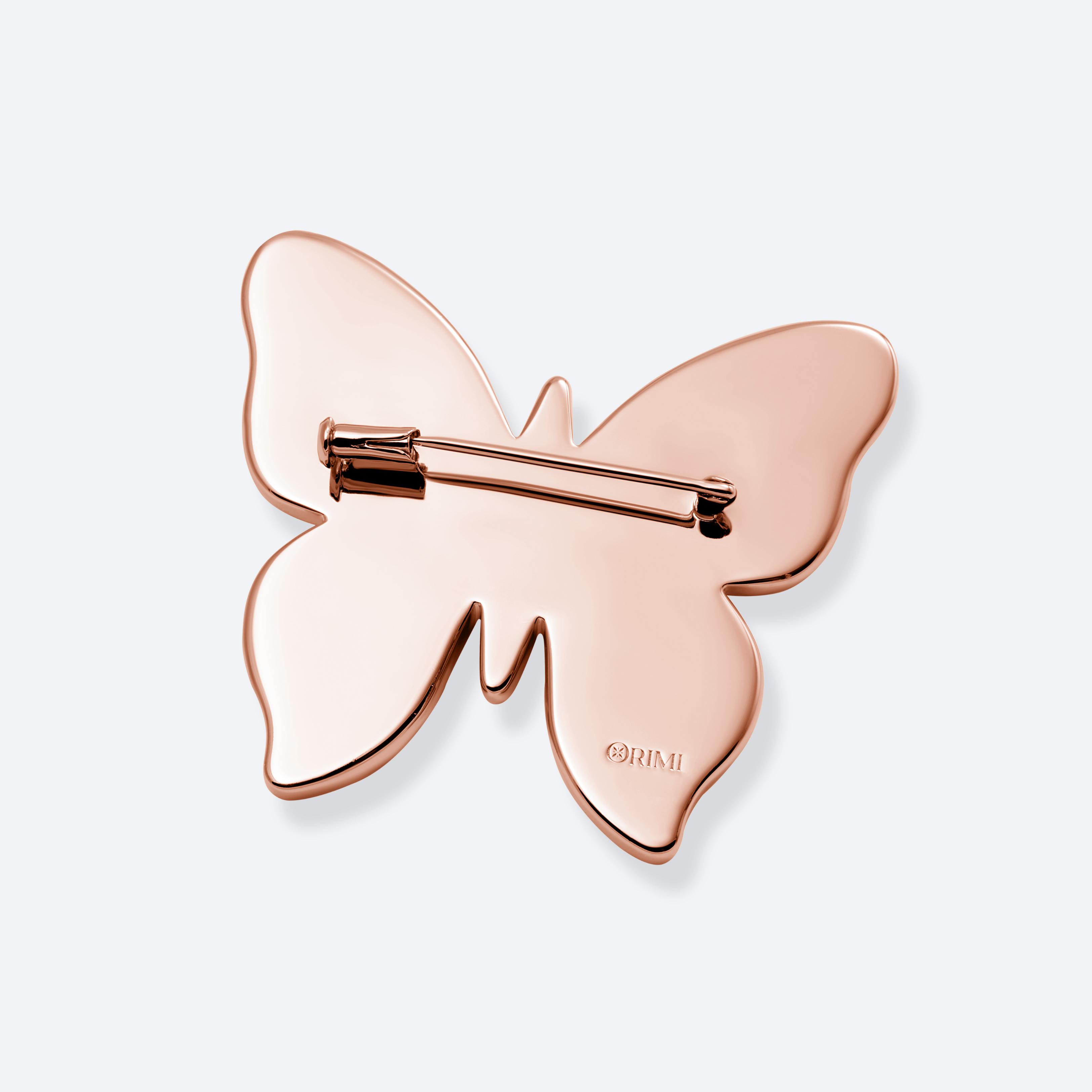 Rose gold butterfly-shaped brooch on a light gray background