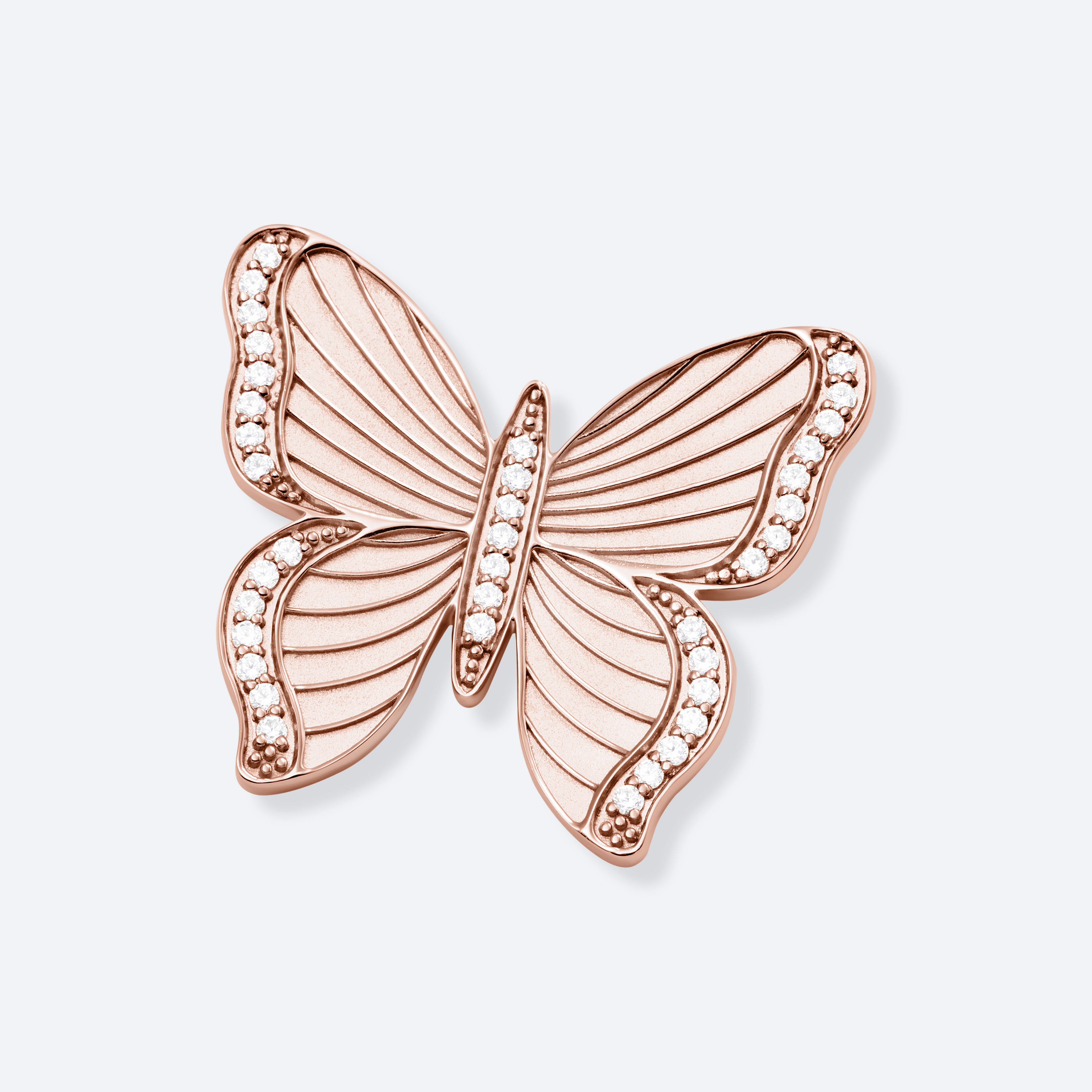 Rose gold butterfly-shaped jewelry piece on a light background
