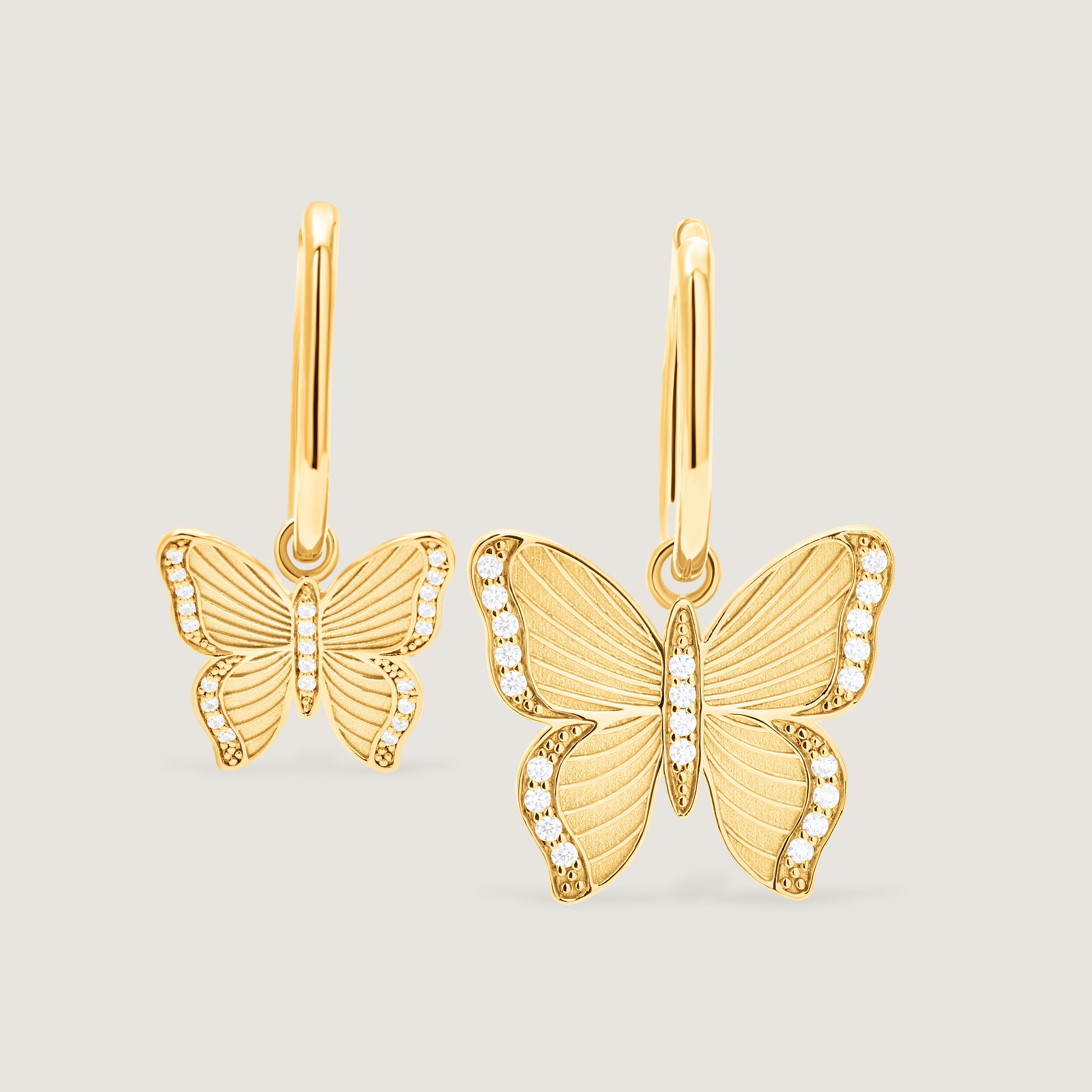 Gold butterfly earrings on a light gray background