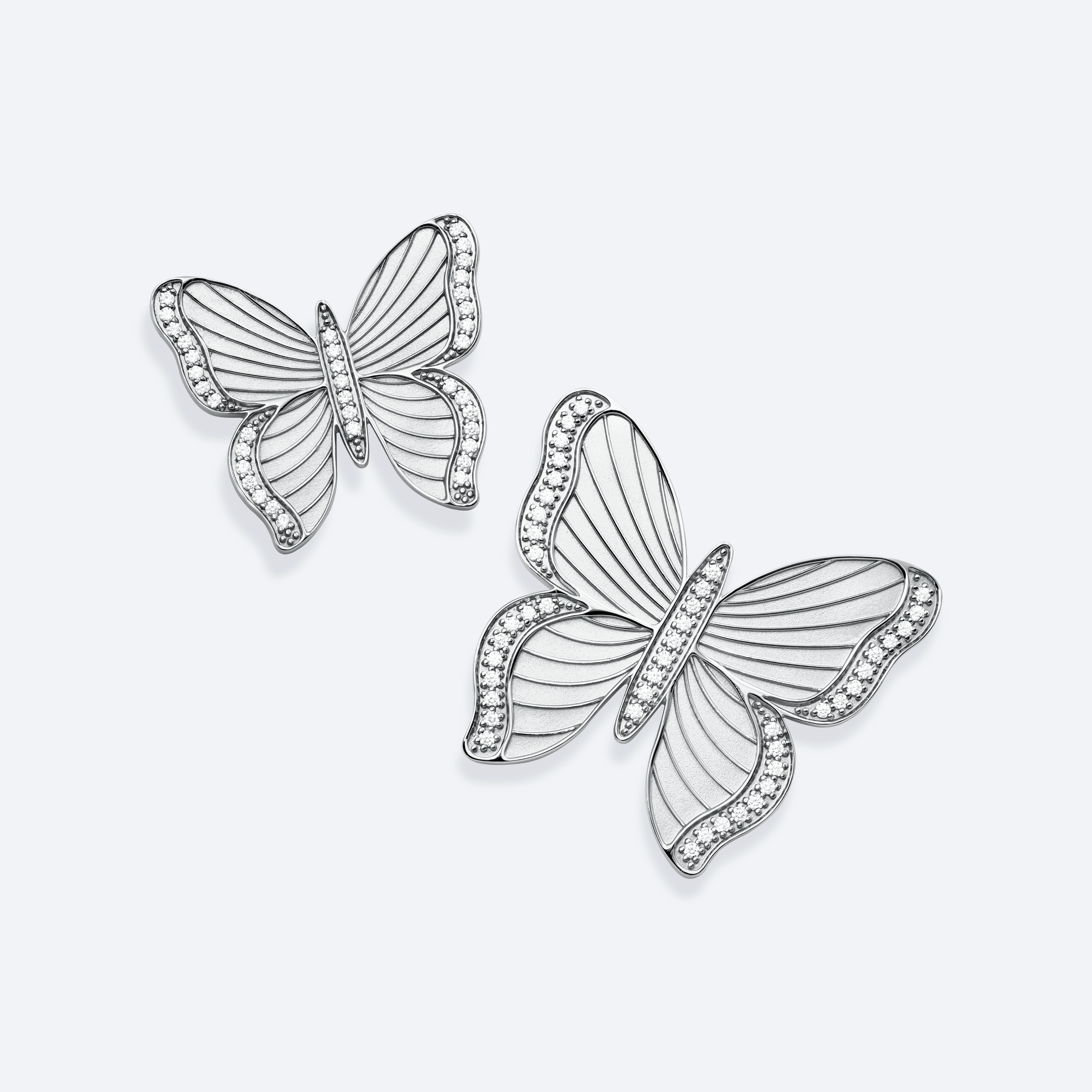 Butterfly-shaped earrings with intricate design on a light gray background