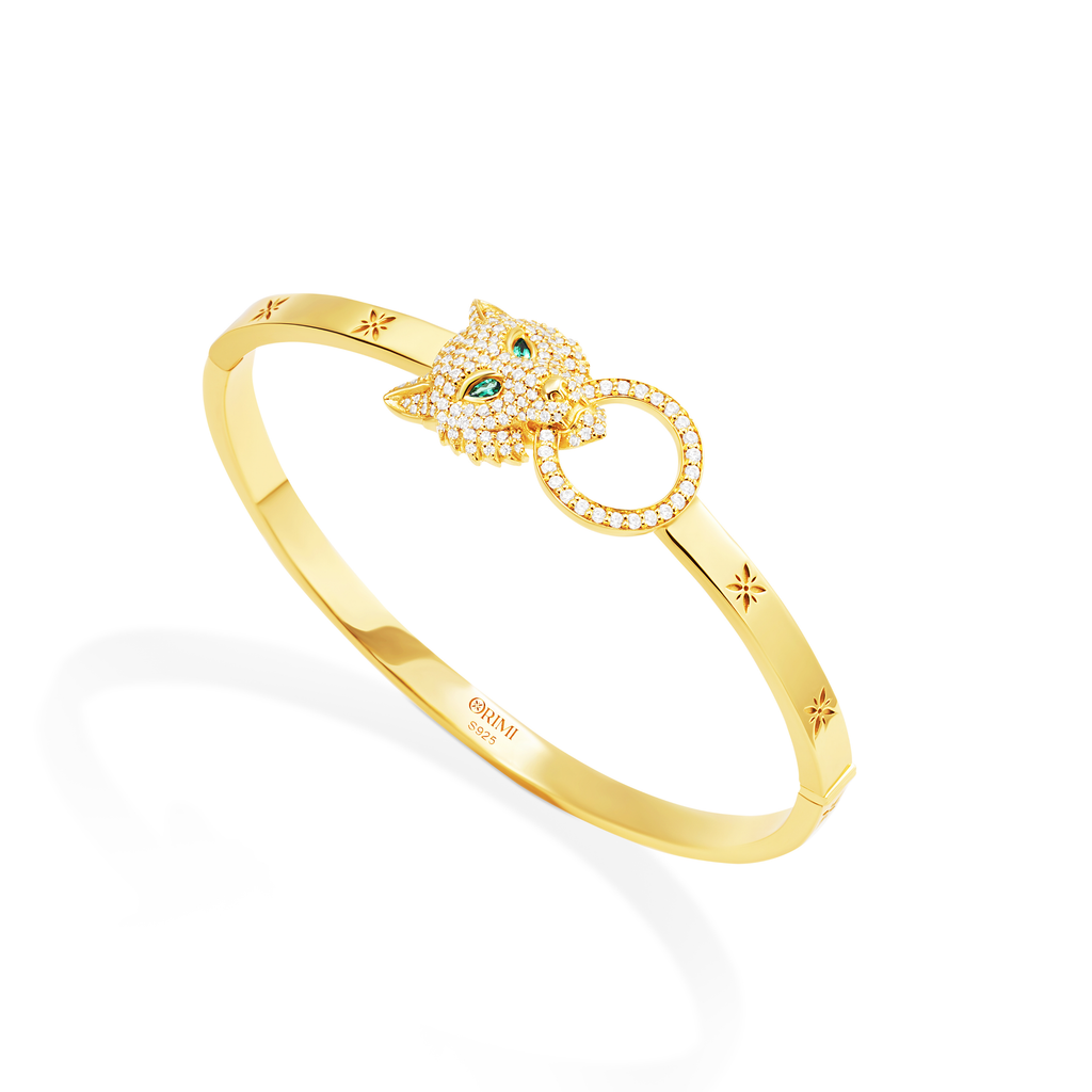 Gold bracelet with a decorative clasp on a white background