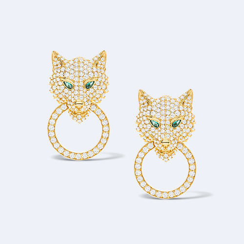 Gold cat-shaped earrings with green eyes on a light gray background