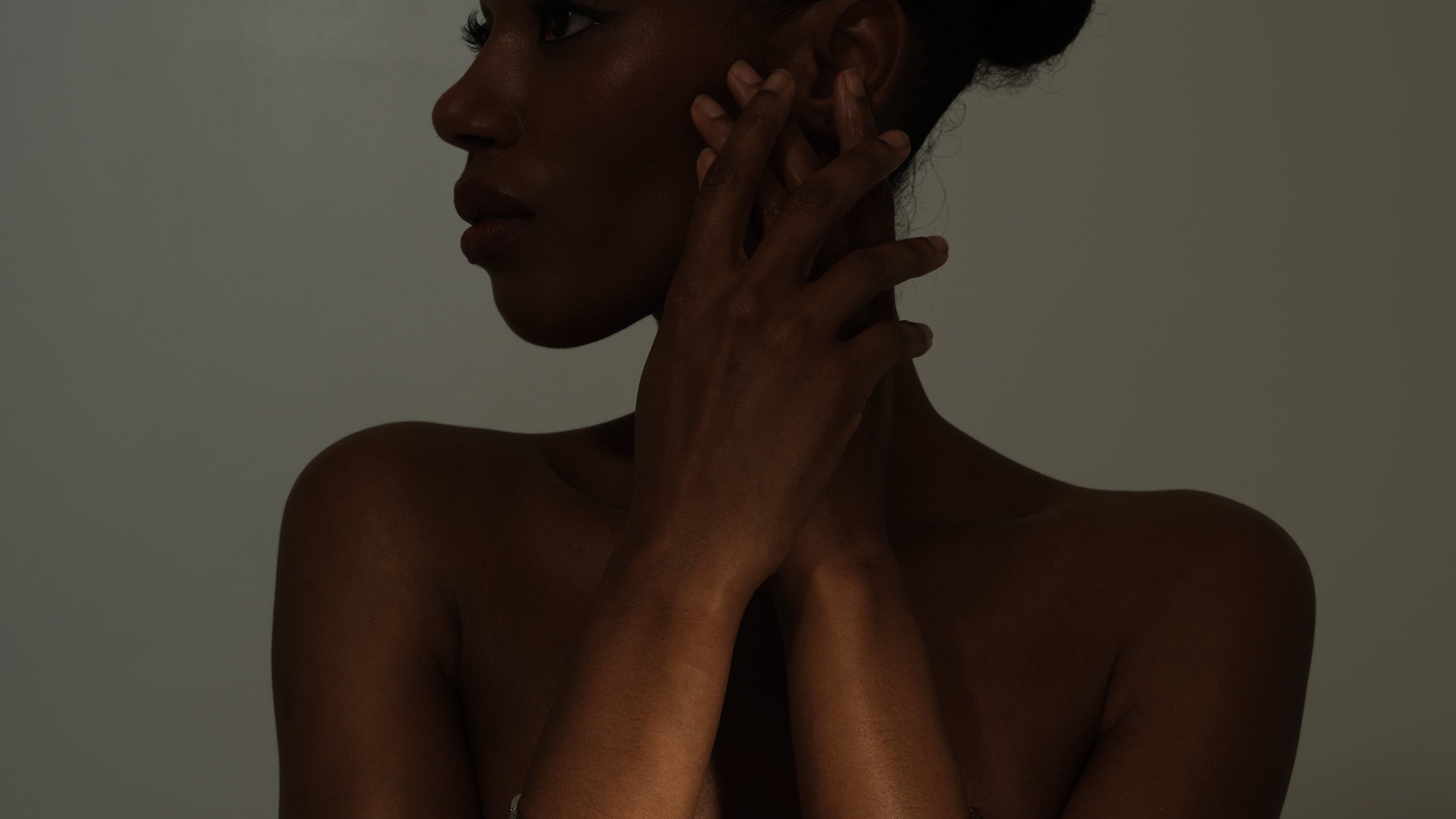 Woman with arm bands against a dark background