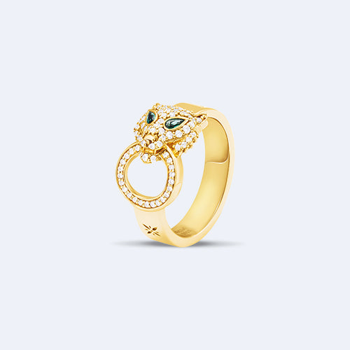 Gold ring with green gemstones on a light gray background