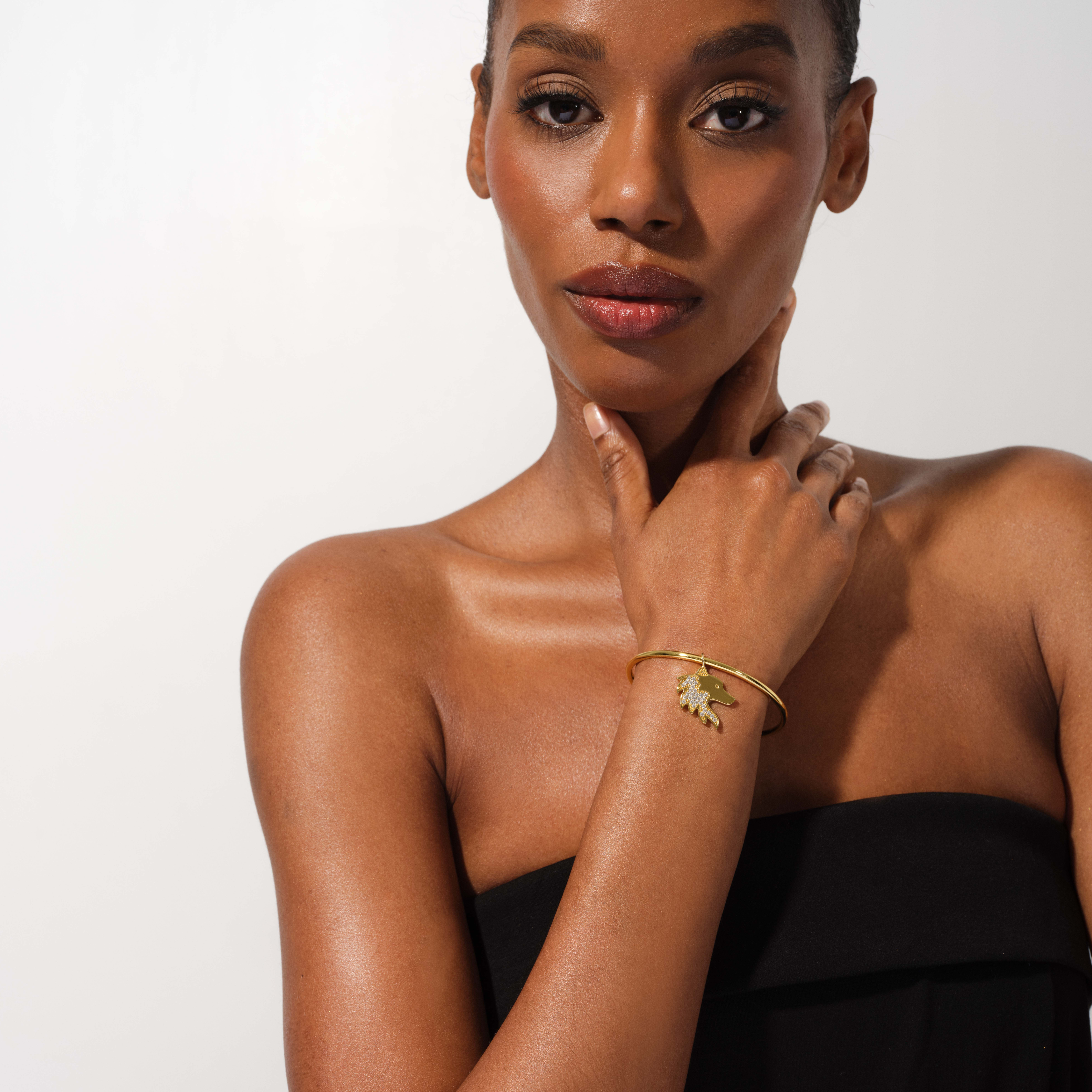 Woman wearing a gold bracelet with a white background