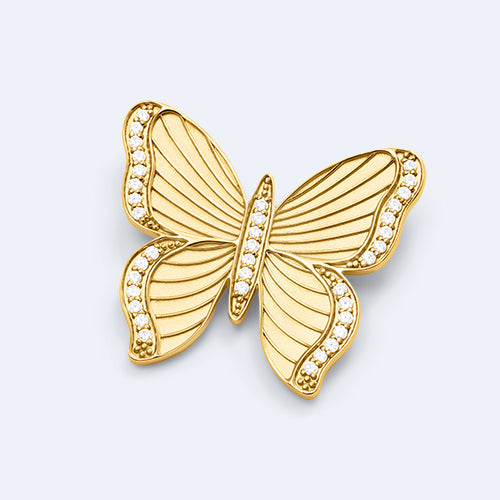 Gold butterfly-shaped pendant with embedded stones on a light gray background