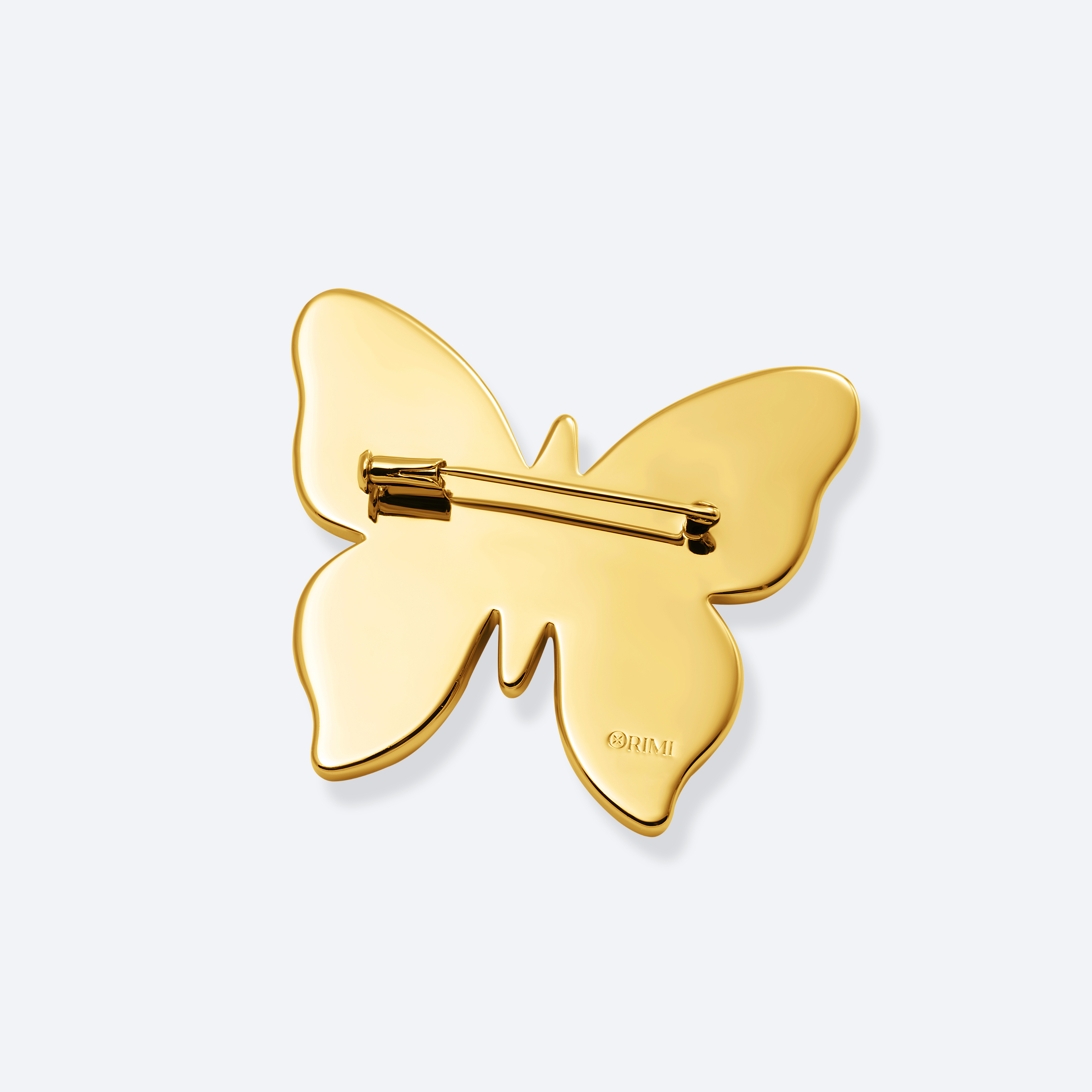 Gold butterfly-shaped brooch on a light gray background